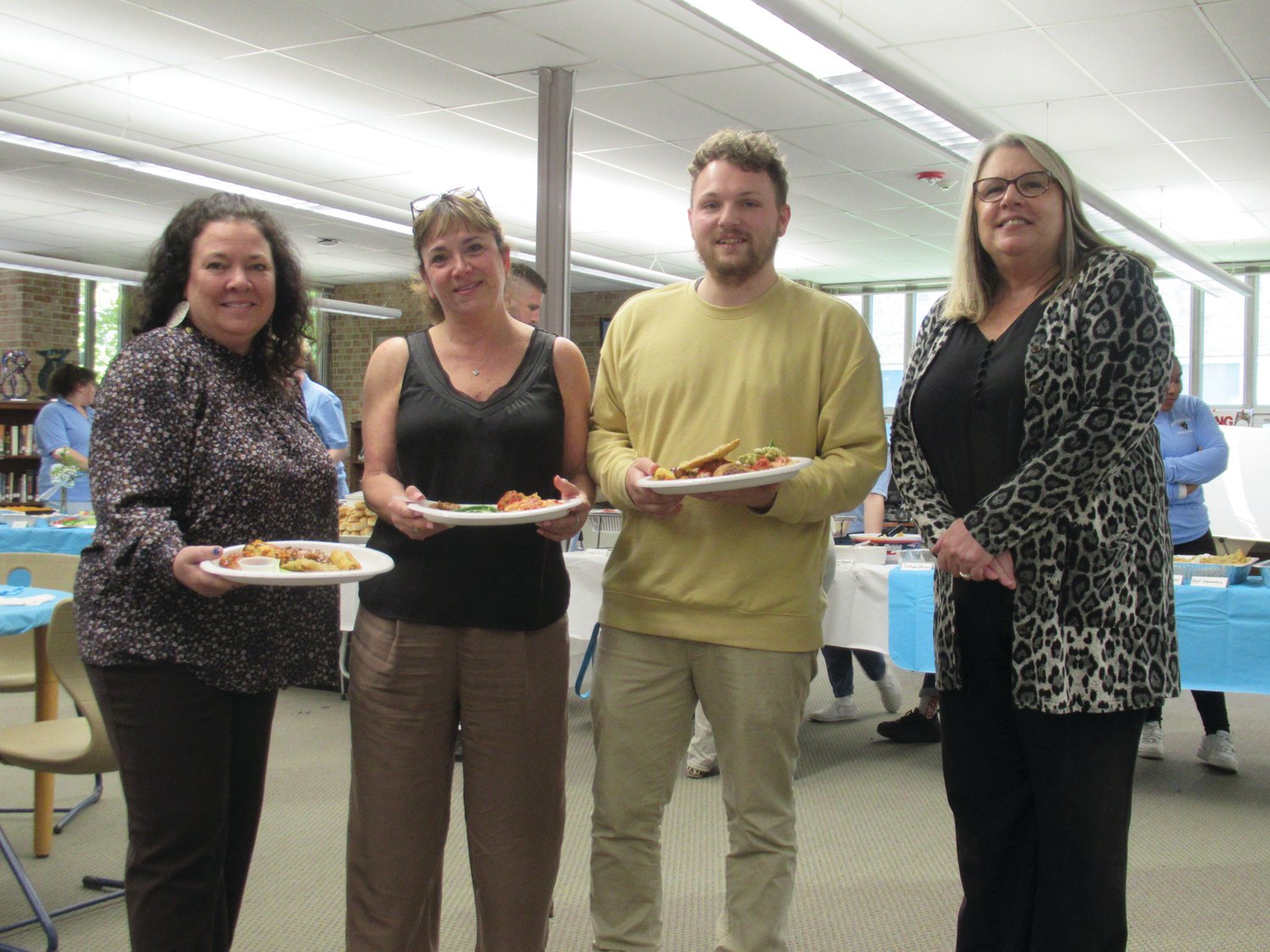 DELIGHTED DINNERS: Teachers Kerry Murphy, Debra Smyth and Mike Harwood join Principal Dr. Donna Pennachia with the plates of “fantastic foods” they selected from a display of 22 homemade items during last week’s Teacher Appreciation Luncheon.